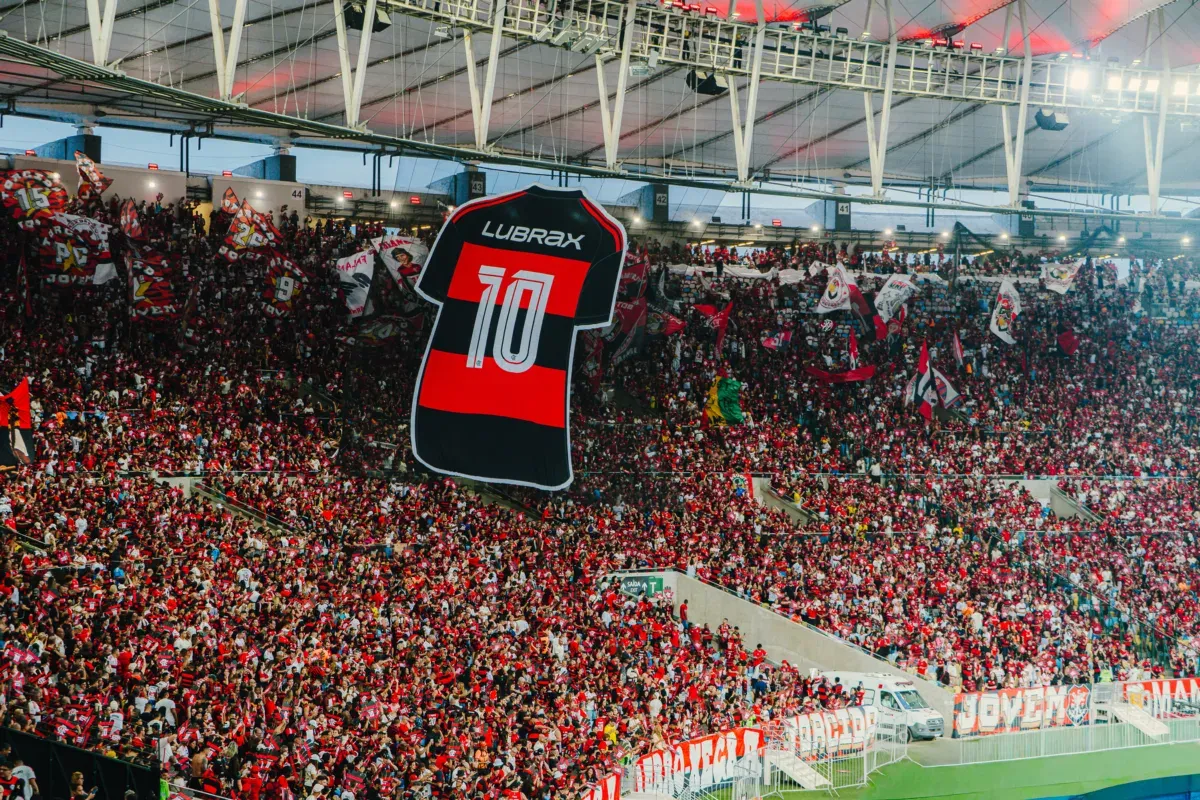 Torcida do Flamengo no estádio com bandeirão da camisa 10 Lubrax